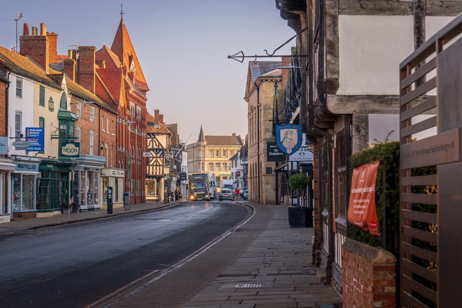 The image shows the exterior of Sutton's Irish Pub on Sutton High Street, characterized by a red storefront with a sign reading 'Sutton's Irish Pub' above the entrance. There are four high tables with